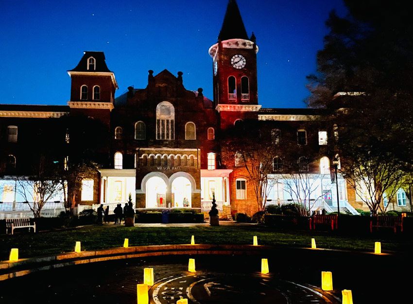 Luminaries along the outside of Wilson Hall at night