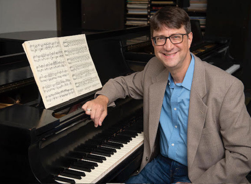 Steven Graff sits at a Steinway piano.