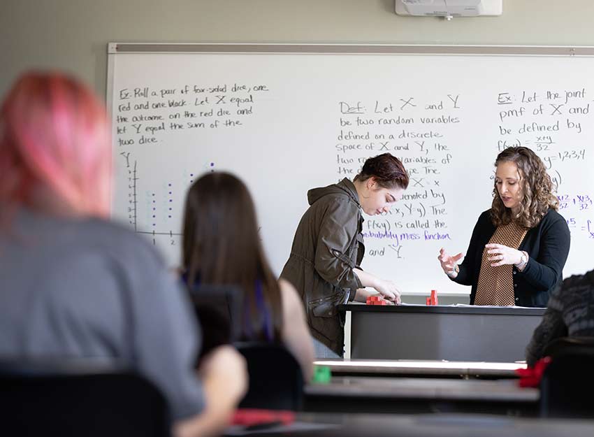 Converse Data Science students in a classroom speaking to faculty