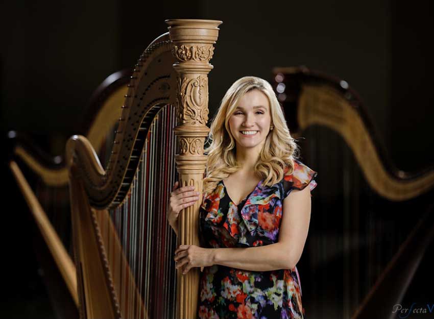 Portrait of Grace Ludtke standing beside her harp.