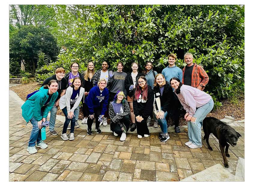 A group of Converse College for Women students standing at Hatcher Garden while doing a service project.