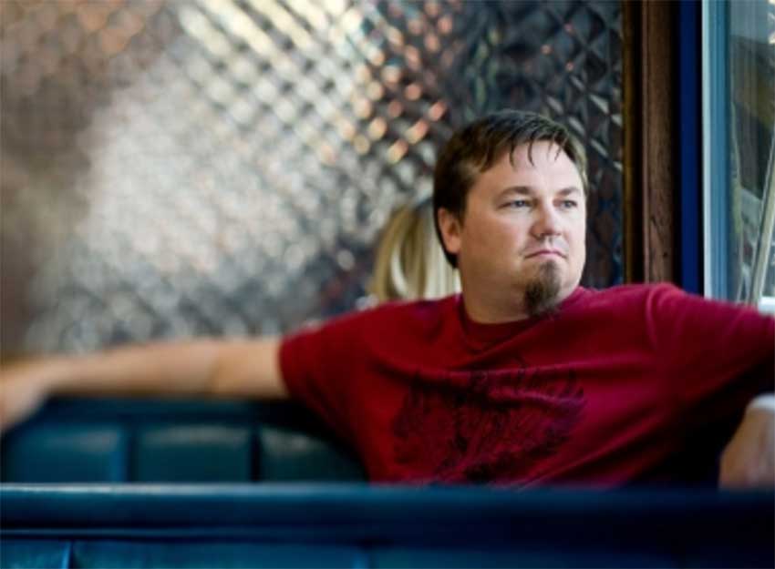 Portrait of Edwin McCain looking out a window with a serious expression.