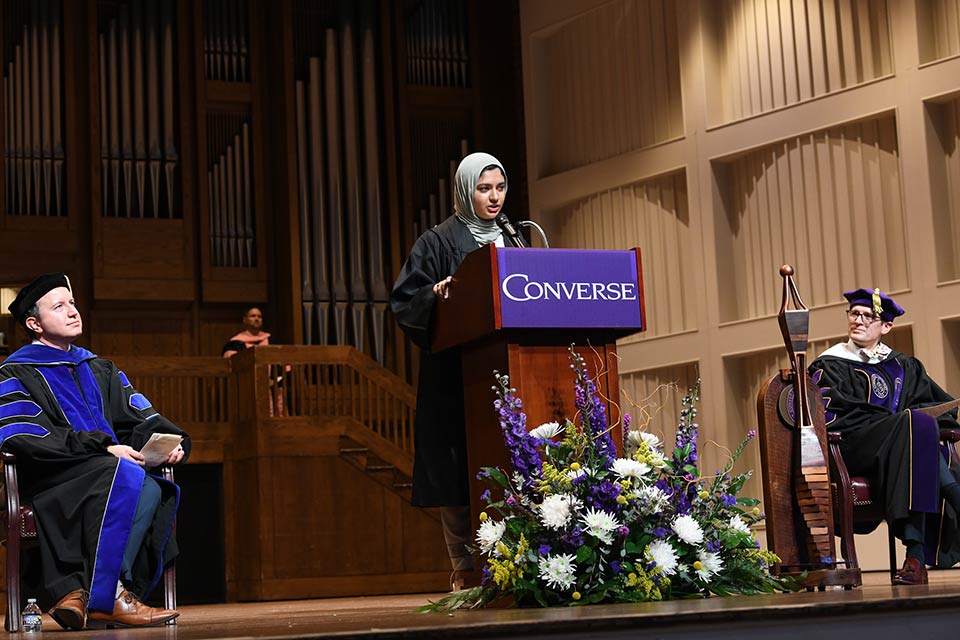 Abeeha Sajid speaks at the podium on stage in Twichell Auditorium.