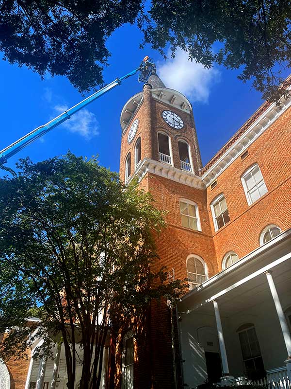 A worker inspects the spire on Wilson Hall's tower.