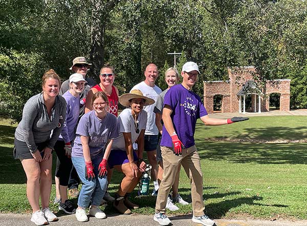 Converse faculty and staff stand in front of Rainey Ampitheater after assisting with cleanup.