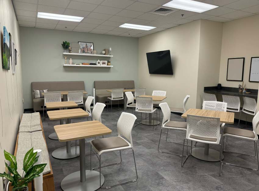 Inside the renovated commuter center at Converse with a new flat screen TV, couches and tables for studying and mingling.