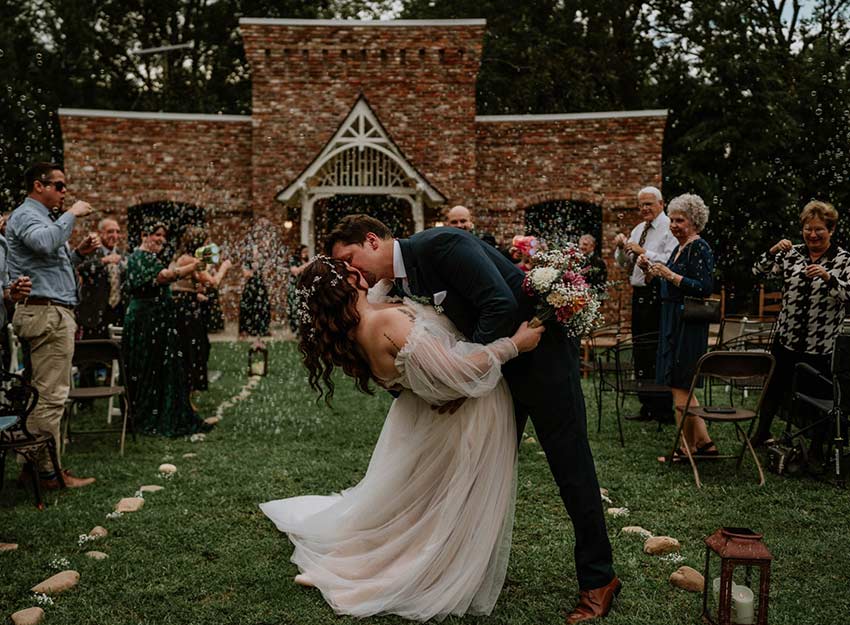 A couple kisses in front of Rainey Ampitheatre on the Converse campus