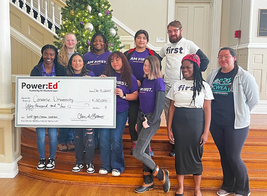 A group of Converse's first-generation students hold a large check up to celebrate a $50,000 Grant from Power:Ed focused on career readiness.
