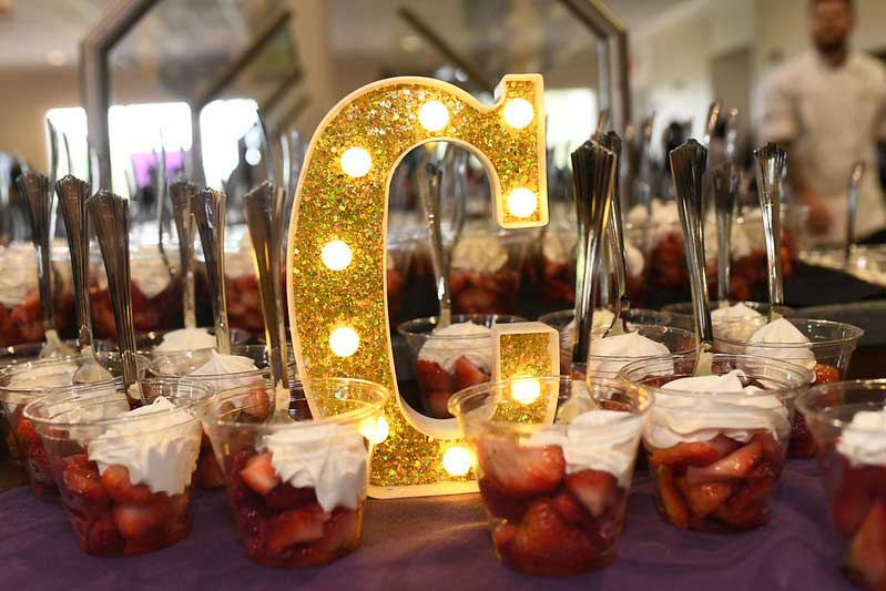 A table filled with strawberries and cream, with a glowing letter "C" in the center.
