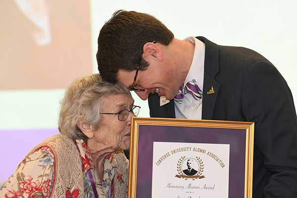 Janis Dengler graciously accepts her alumni achievement award from President Boone Hopkins